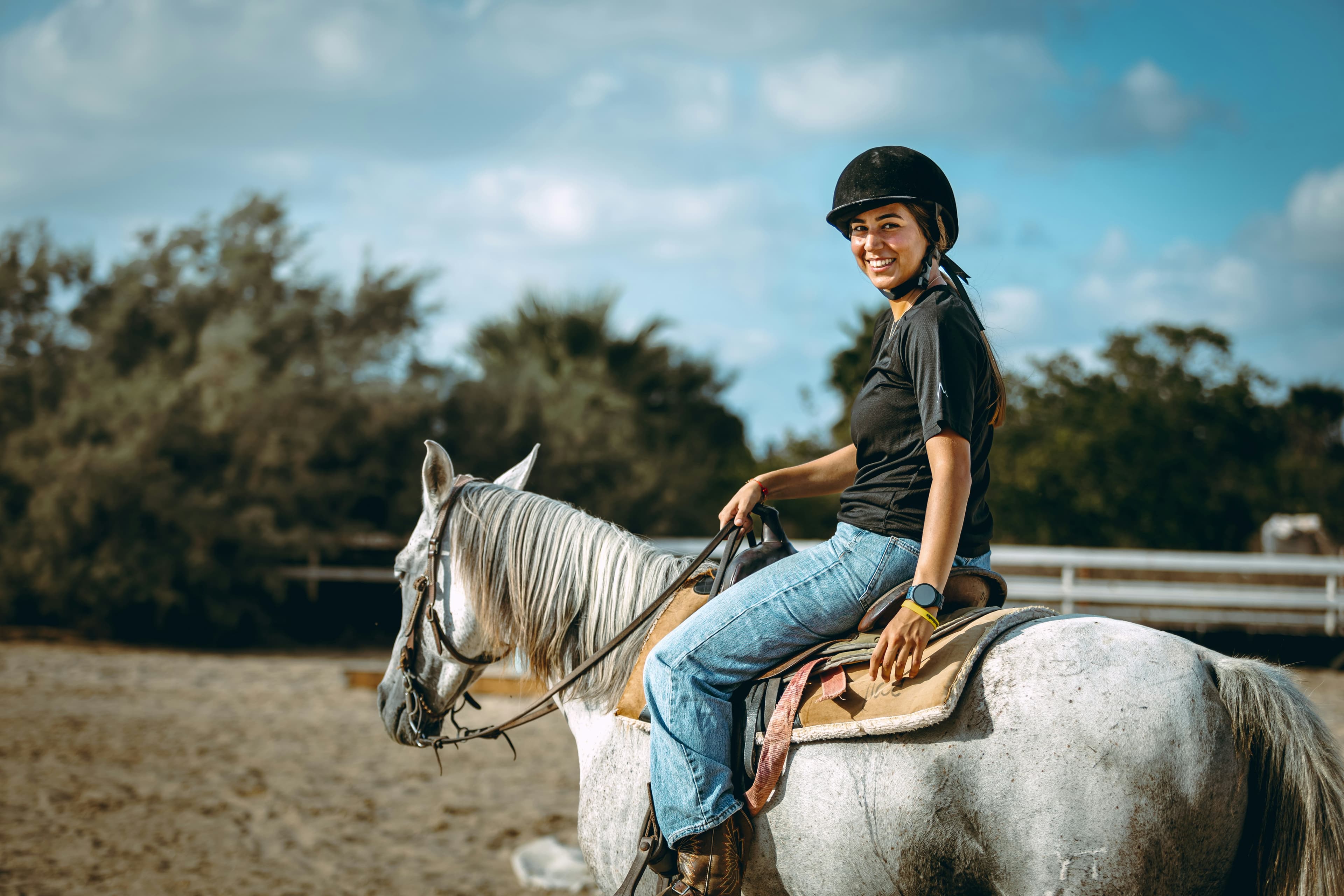 Rider wearing a helmet beside a horse.